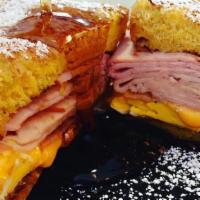 Mesa Cristo · French toast filled with sliced turkey, 2 eggs over hard, bacon, American cheese, and sprink...