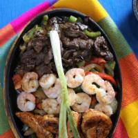 Sizzling Fajitas - Trio Fajitas · Grilled steak, shrimp and chicken with fresh peppers, onion, tomatoes, and spices. Served wi...