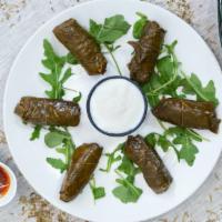 Stuffed Grape Leaves (Dolmas) · Grape leaves stuffed with rice and flavorful herbs. Served with yogurt.  Comes with a pita b...