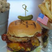 All-American Burger · Topped with onion rings, two slices of crisp bacon, BBQ sauce and mild cheddar cheese.