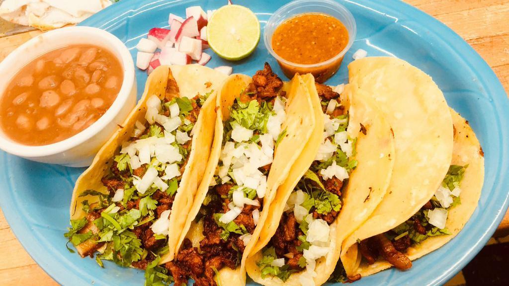 Tacos Al Pastor · Four tacos filled with pork meat with special sauce, pineapple, cilantro and onions served with whole black or pinto beans.