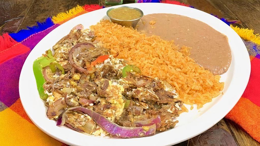 Machaca · Tender shredded beef, grilled onion, bell pepper and egg scramble. Choose rice and beans or potatoes on the side.