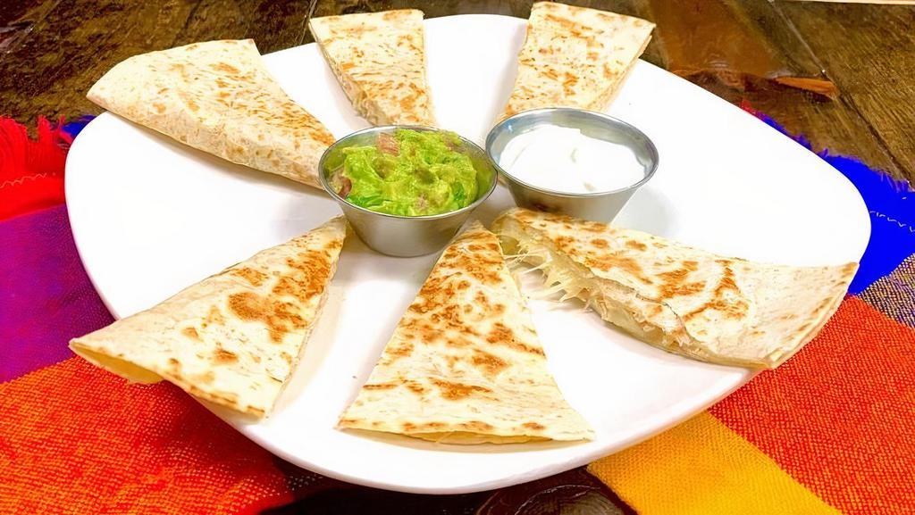 Quesadilla Slices · Shredded chicken and cheese quesadilla slices with guacamole and sour cream on the side.