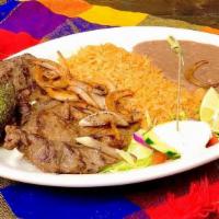 Res A La Plancha · Grilled asada steak with grilled onions on top. Plate includes rice, beans and tortillas.