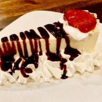 Cheesecake · Creamy classic cheesecake slice with whipping cream on the sides, a hint of strawberry sauce...