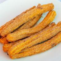 Churros · Seven churros tossed with sugar and cinnamon.