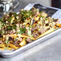 Khan Fries · Bed of fresh fries topped with scrambled chapli kabob, mint chutney, fresh herbs and freshly...