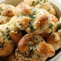 Garlic Knots · Delicious dozen of mini dough balls tossed in garlic oil, parmesan, oregano and basil.