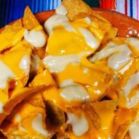 Cheese Nachos · Freshly made nacho chips, topped with nacho and queso Blanco cheese.