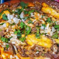 Beef Birria Fries · Fries topped with birria and melted cheese, topped with consommé and cilantro & onions.