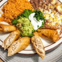 Chingolingas · A flaky pastry filled with chicken served with rice and beans, garnished with guacamole and ...