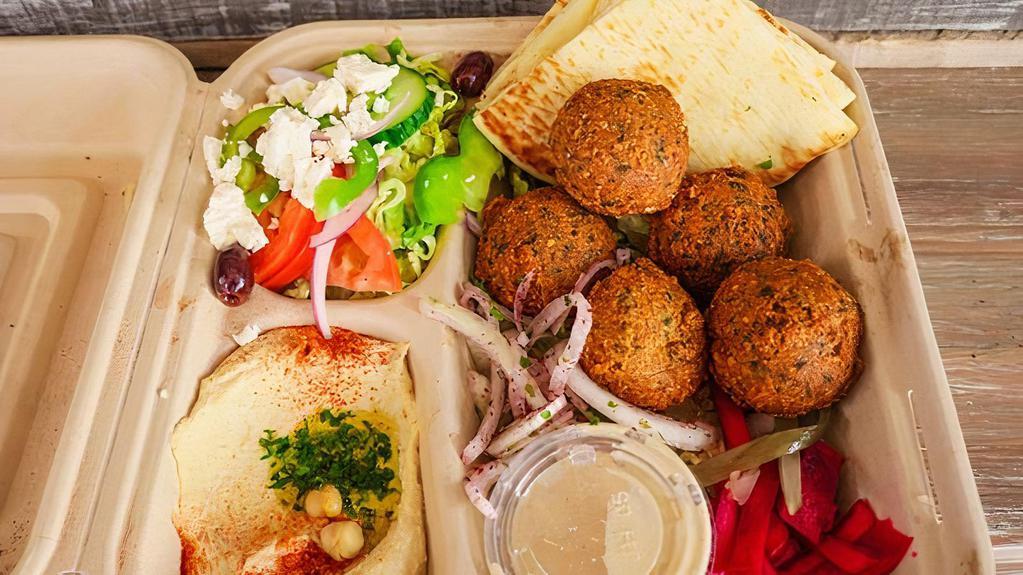 Falafel Plate · Delicious hot vegan falafels (6 pieces), served with fresh garden salad, rice, hummus, housemade tahini, and warm pita bread.