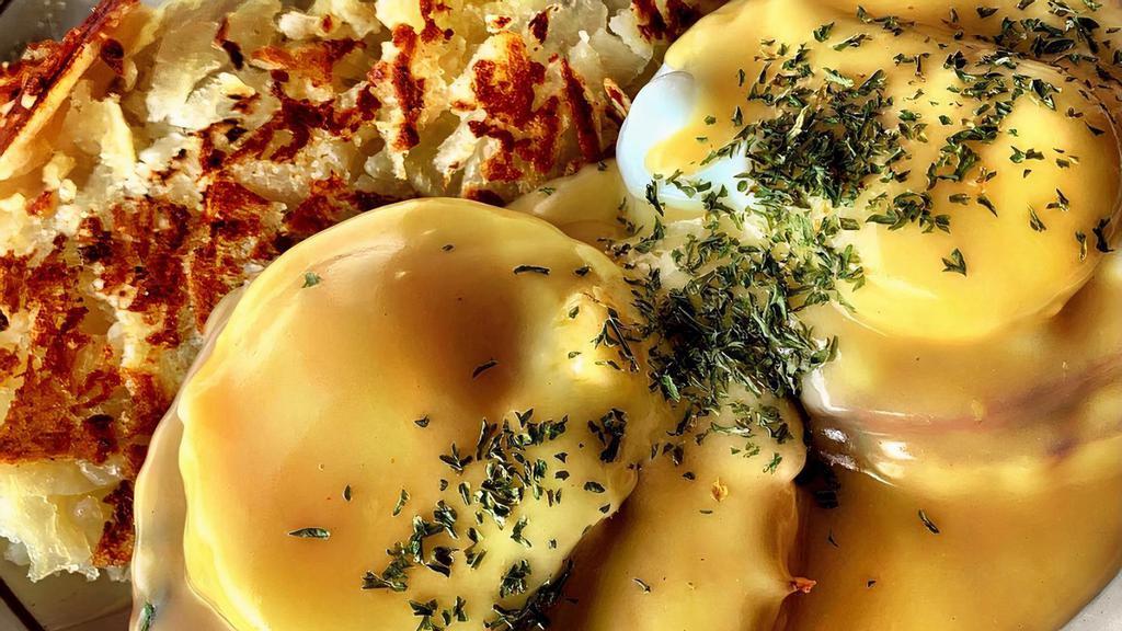 Eggs Benedict · Traditional Egg's Benedict with poached eggs on english muffin topped with creamy Hollandaise sauce. Comes with Canadian Bacon and choice of a side.