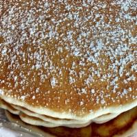 Short Stack Of Pancakes · 3 fluffy buttermilk pancakes with powdered sugar. Butter and syrup on the side.