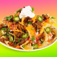 Breakfast Nachos · Melty nachos loaded with bacon, fried eggs, nacho cheese, pico de gallo, pinto beans, and yo...