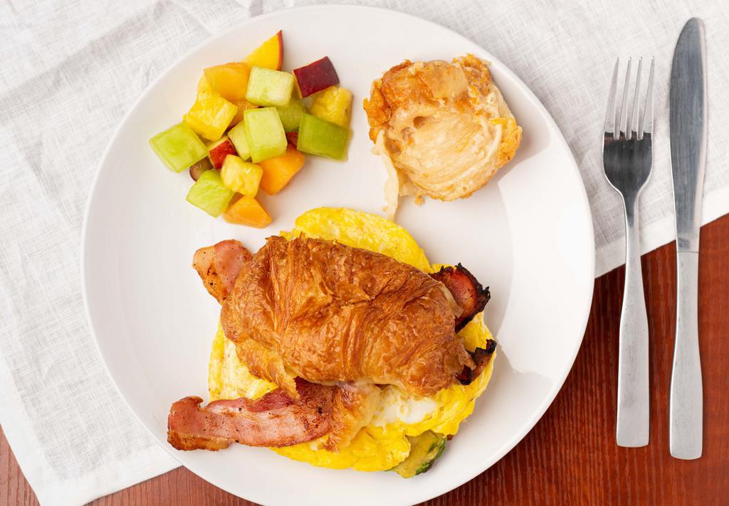 Breakfast Muscle Sandwich · Two scrambled eggs, avocado, Swiss cheese and choice of bacon, turkey or ham in a French butter croissant. Served with potatoes gratin and fresh seasonal fruits.