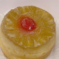 Upside-Down Cake · Baked butter and brown sugar, pineapple slice, cherry, and yellow cake
upside-down on the pan.