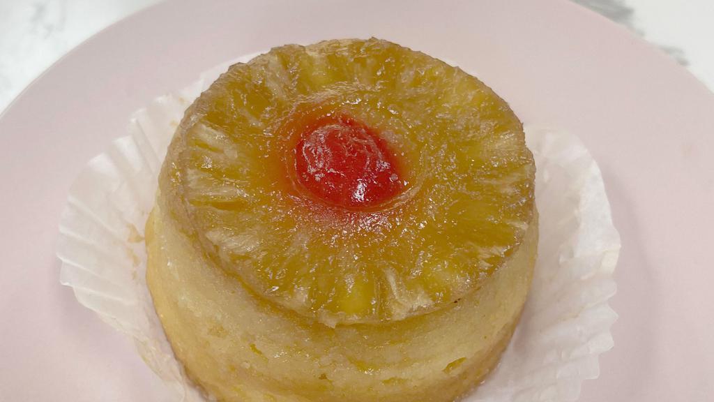 Upside-Down Cake · Baked butter and brown sugar, pineapple slice, cherry, and yellow cake
upside-down on the pan.