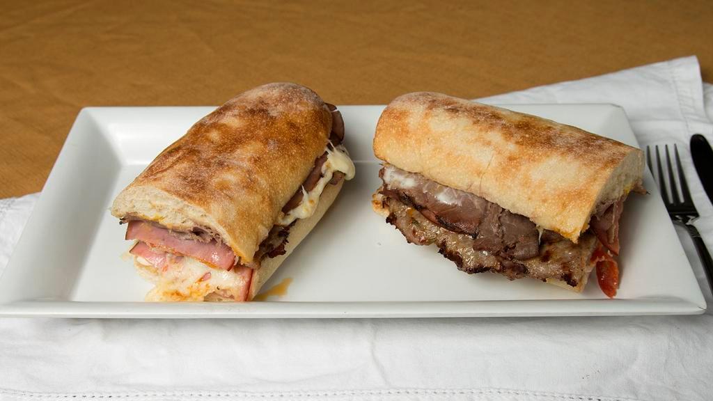 Monster Combo · Roast beef, ham, pepperoni, Italian sausage, and cheese.  Comes with a mayo and mustard sauce.  Lettuce, onions, tomatoes and pepperoncinis are served on the side.  We bake our bread daily and it measures in at just under a foot.