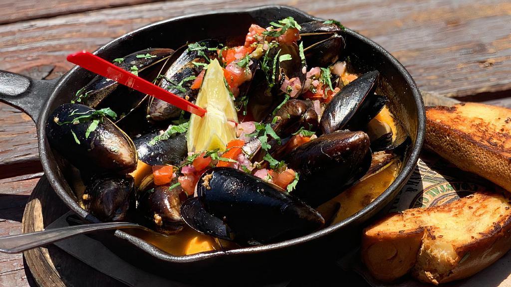 Steamed Mussels · Simmered in a cast iron skillet with white wine fresh lime, tequila, tomato, garlic butter, chorizo, cream, cilantro.