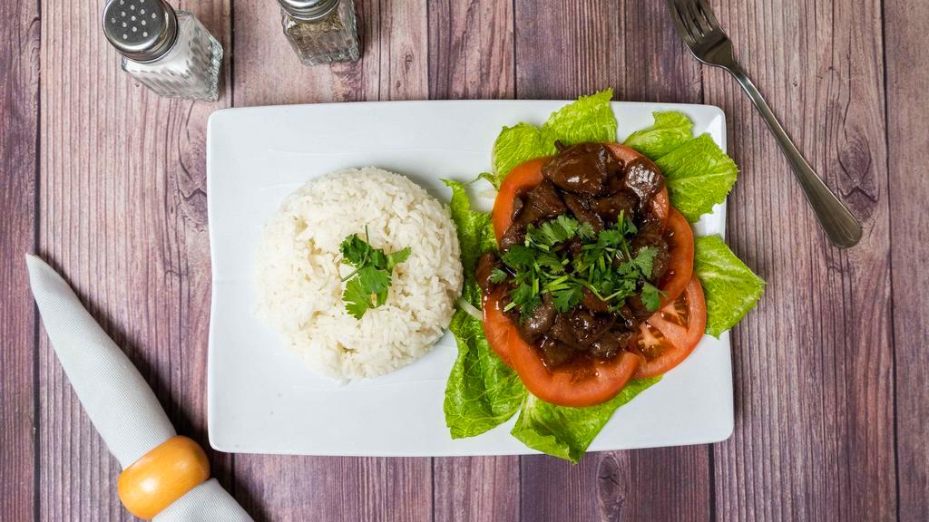 Lok Lak (Cambodian Beef Stir-Fried) · Garlic, stir-fried with seasoned beef pour on the top of slice onions & tomatoes, (add fried egg for an additional price).