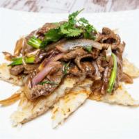 Mongolian Beef · sliced beef seared with onion and scallion served over rice noodles