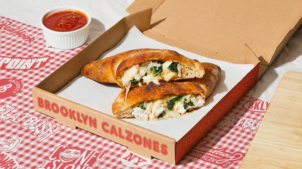 Williamsburg Calzone · Calzone with fresh spinach, garlic, creamy ricotta, melted mozzarella, and a side of marinara.