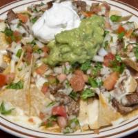Amigos Nachos · Tortilla chips topped with refried beans, Monterey Jack cheese, sour cream, guacamole, pico ...