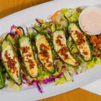 Jalapeño Poppers · Fresh grilled jalapeños halved and stuffed with a spinach and garlic cream cheese topped wit...
