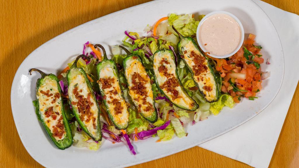 Jalapeño Poppers · Fresh grilled jalapeños halved and stuffed with a spinach and garlic cream cheese topped with bacon.