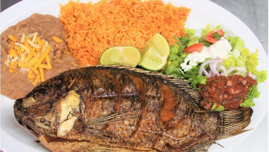 Mojarra Frita · Whole tilapia served with salad, rice and beans.