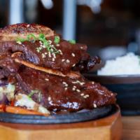 Korean Bbq Ribs · Grilled marinated short ribs served on a bed of stir-fried vegetables with rice; topped with...