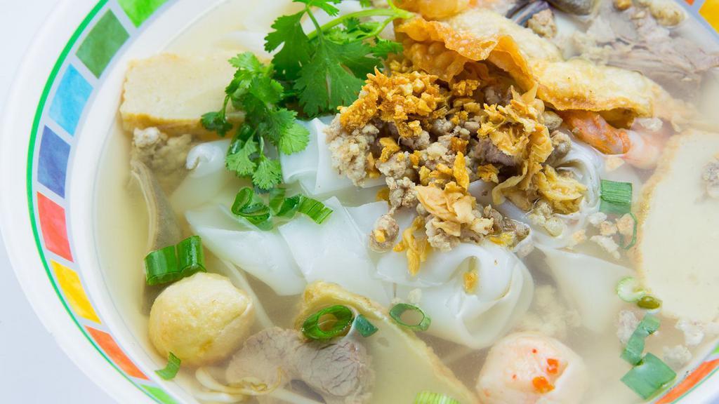 Sanamluang Noodles · Flat rice noodles soup with pork, ground pork, fish ball, fish cake, shrimp and bean sprouts topped with fried wonton.