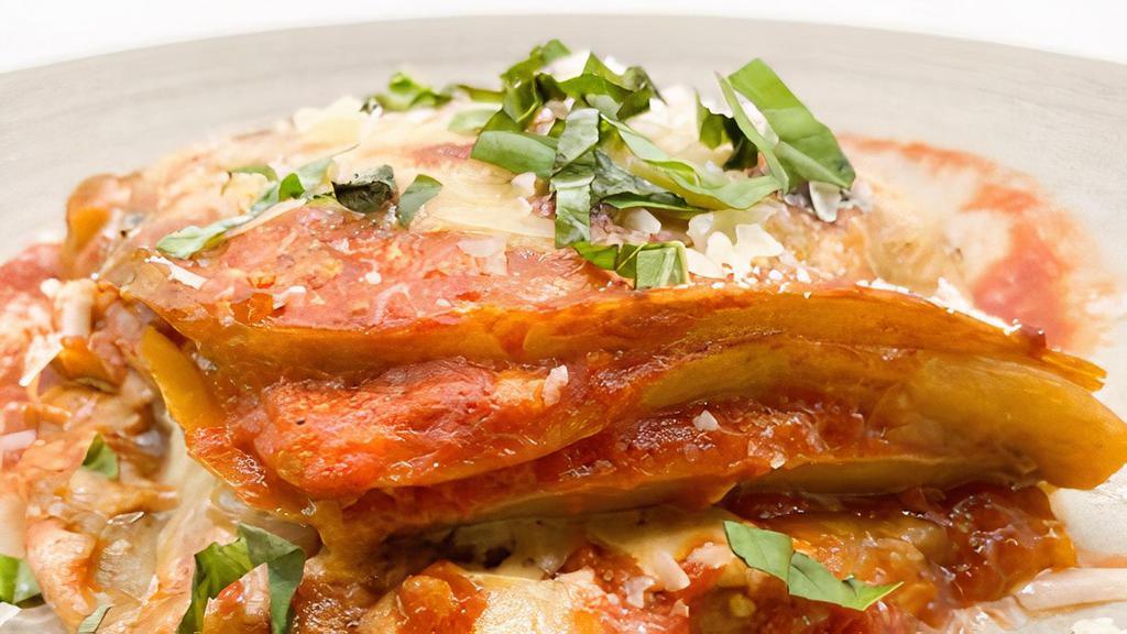 Eggplant Parmigiana · Layers of grilled eggplant, tomato sauce, and shredded mozzarella, topped with Parmesan cheese.
