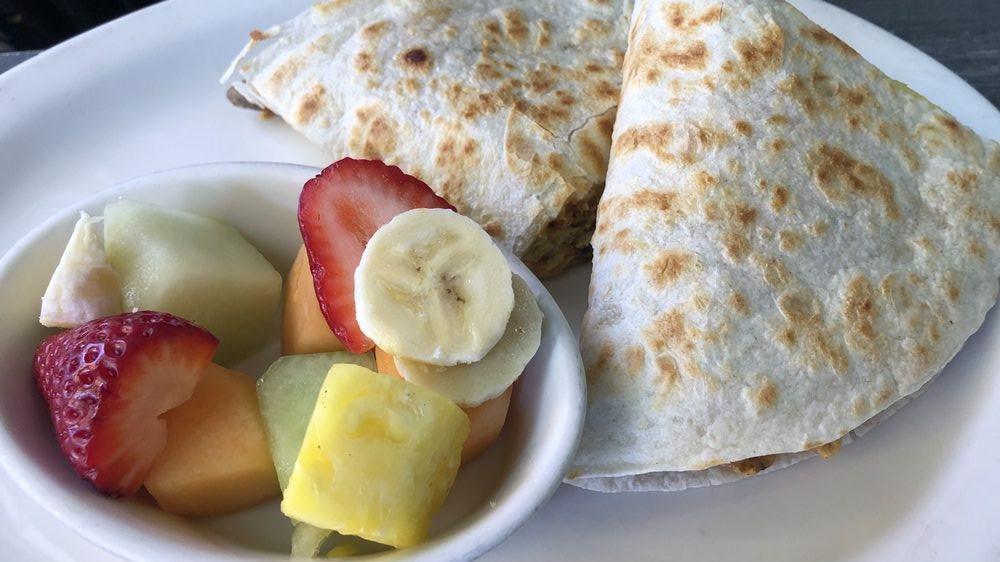 Breakfast Quesadilla · Jack and cheddar cheese, pico de gallo, guacamole, mushrooms, scrambled eggs, and your choice 
of bacon, turkey bacon, or ham. served with fresh fruit or roasted potatoes.