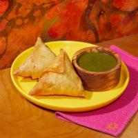 Vegetable Samosas · Two samosas filled with seasoned potatoes and peas and wrapped in a light pastry.