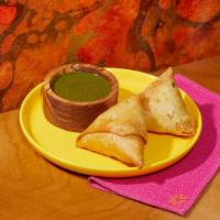 Lamb Samosas · Two samosas filled with lamb and wrapped in a light pastry.