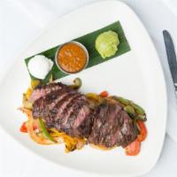 Fajitas De La Casa · Grill chicken, Sautéed peppers and onions, sour cream, guacamole, rice, refried beans, and h...