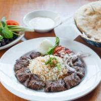 Lahm Mishwi (Shish Kabab)  · Tender cut, seasoned and char-broiled. Served with rice, pita bread, barbecued tomato, and o...