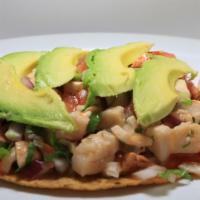 Ceviche Tostada · Shrimp and fish served with onion, cilantro, tomatoes, and avocado.
