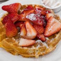Fresh Strawberry Patch Waffle · A waffle dusted with powdered sugar, topped with fresh strawberries, and real whipped cream.