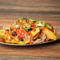 Nachos The Works · Crispy corn tortilla chips topped with nacho cheese, your choice of meat and any of our vari...
