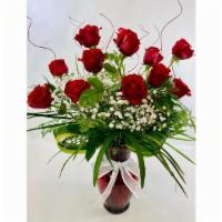 A Dozen Long Stem Red Roses · A beautiful dozen long stem red roses surrounded by rich greenery, in a classic tall glass v...