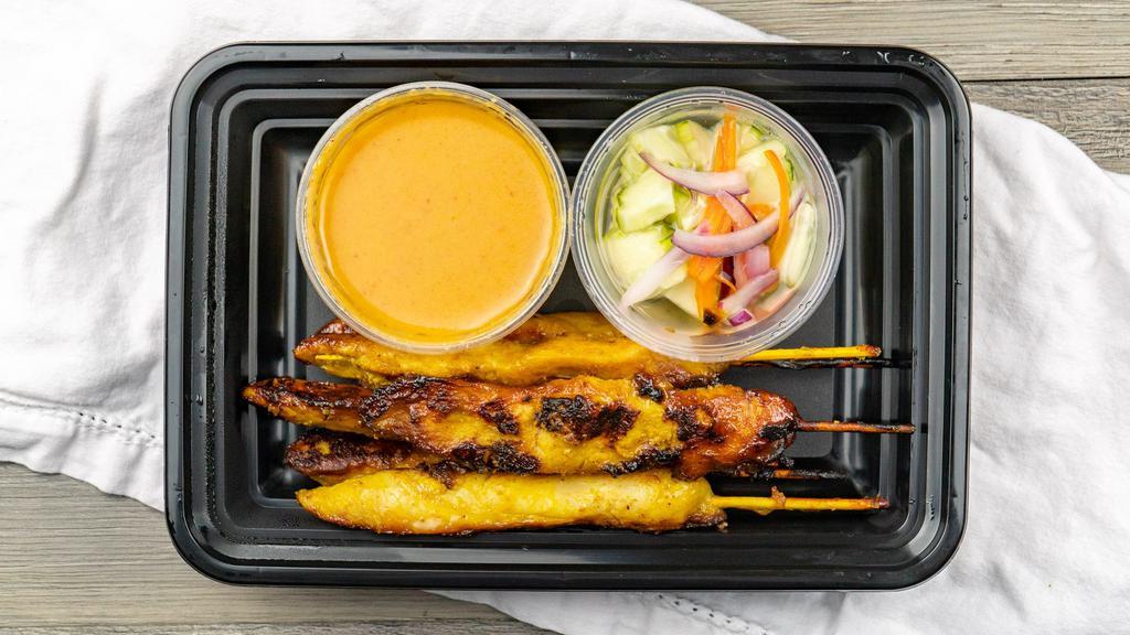 Chicken Satay · Marinated chicken skewers in a coconut milk and curry powder served with peanut sauce and cucumber salad.