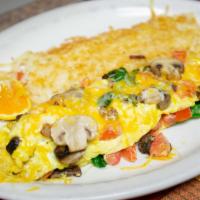 Veggie Omelette · Filled with Monterey jack and cheddar cheese, tomatoes, mushrooms and spinach. Served with b...