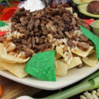 Nachos · tortillas chips ..avocado.beans. carne asada and sourceam.. cheese