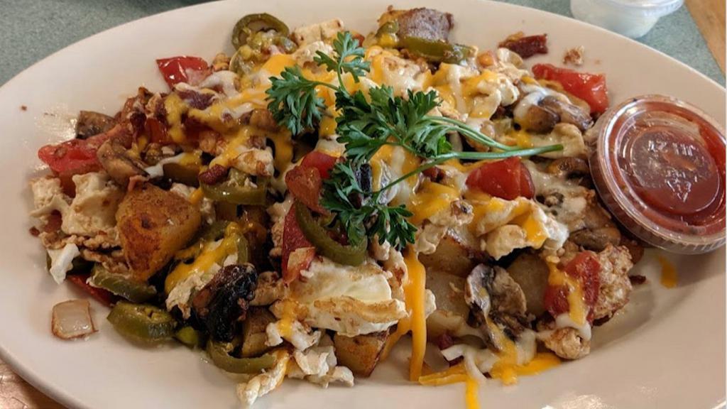 Spicy California Skillet · Our home-style potatoes topped with bacon, mushrooms, tomatoes, jalapeños, scrambled eggs and melted cheese. Served with a side of sour cream and salsa.