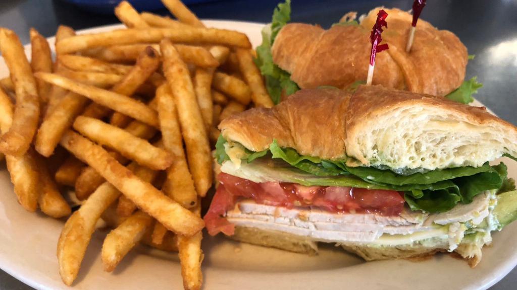 Turkey Croissant Sandwich · Thin sliced turkey breast served with lettuce, tomatoes, cheese, mayonnaise ​and avocado.