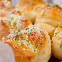 Cheesy Garlic Knots · Fresh baked garlic knots smothered in cheese.