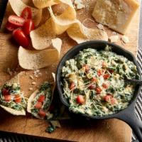 Spinach Artichoke Dip · Slow-baked with four cheeses and served with crisp tortilla chips.